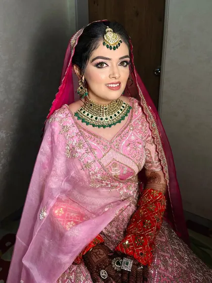 Pretty in pink. This bride's look is soft and romantic, a perfect match for her organza dupatta and green jewelry.