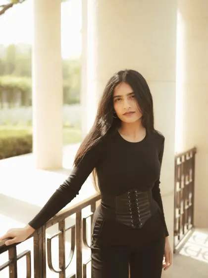 A simple and direct portrait from the same series, with the subject leaning against a railing. The clean background and natural light keep the focus entirely on the person.