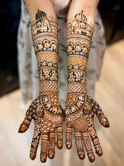 A straight-on view of the elephant and peacock design, showing the rich, dark paste.