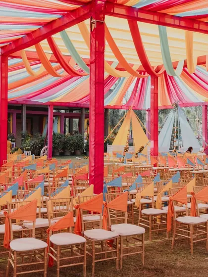 The seating arrangement for a large Haldi ceremony. The colorful ceiling drapes and chair ties brought the entire space to life, creating a cohesive and festive look.