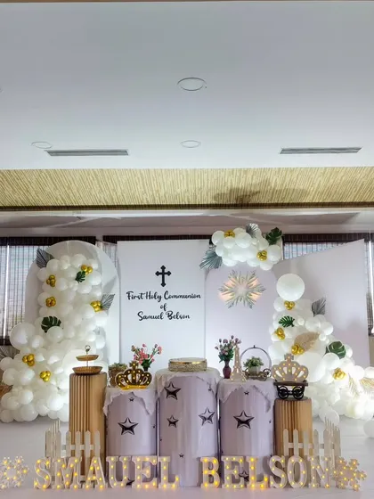 A beautiful First Holy Communion setup with an all-white theme and touches of green and gold.