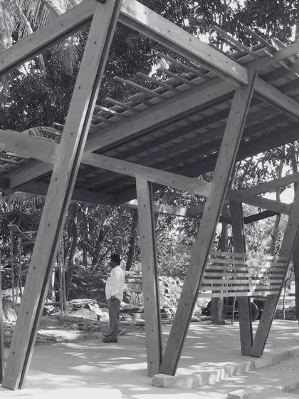 A reflective moment during the construction of K-Lagoon. The angular timber frame structure stands in dialogue with the organic forms of the surrounding trees, a synthesis of the man-made and the natural.