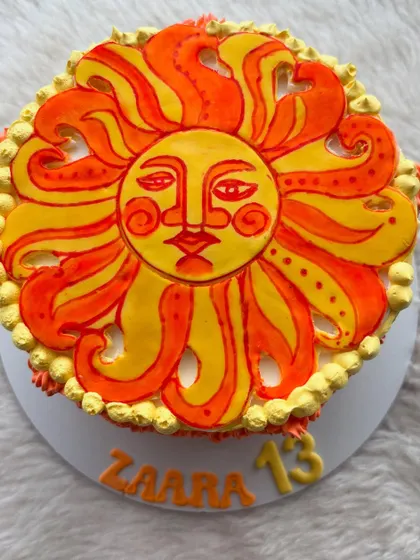 A hand-painted sun cake for a 13th birthday. The bright orange and yellow design is so cheerful.