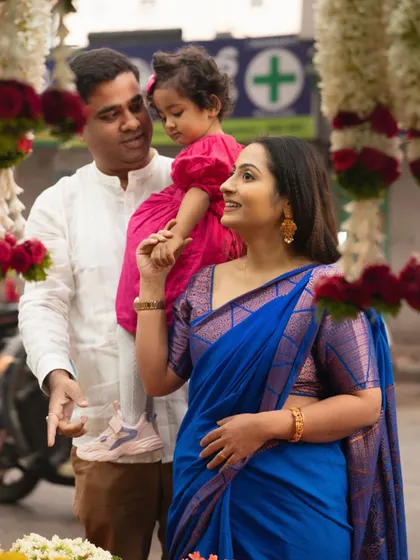 A lovely family portrait at the flower market. The mother and daughter's interaction, with the father looking on, creates a heartwarming and candid scene.