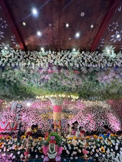 An incredible overhead view of a naming ceremony, with the entire ceiling and stage area covered in a dense arrangement of fresh flowers. This is how I turn a simple hall into a floral wonderland.