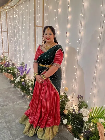 A client looking lovely in a red and green Bandhani-style half saree, perfect for a wedding or festive party.