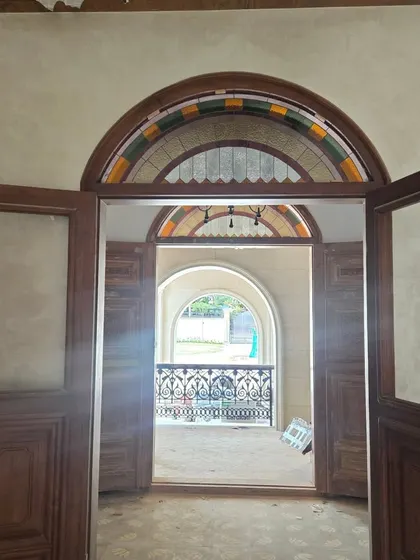 Looking through a set of grand double doors to an arched balcony at the Veerabhavana Villa. This view, even during construction, shows how we designed layers of spaces and framed views to create a sense of depth and discovery.