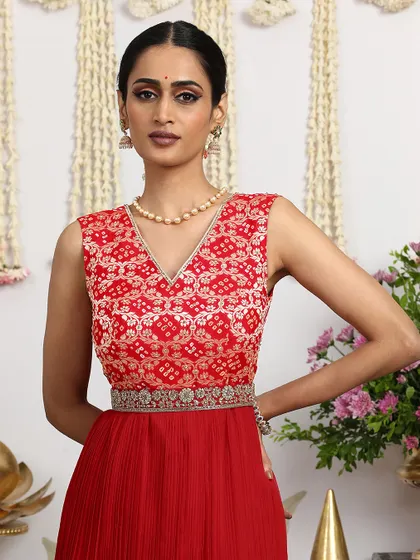 A close-up of the red Bandhani dress, showcasing the intricate tie-dye pattern and the delicate embroidery on the yoke.