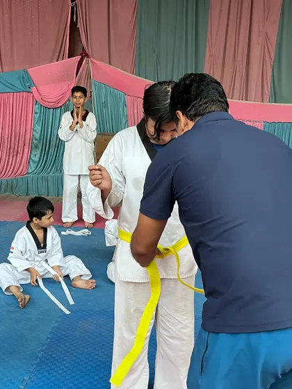 The moment of promotion is a special one. This photo captures a student receiving her new belt after a successful test.