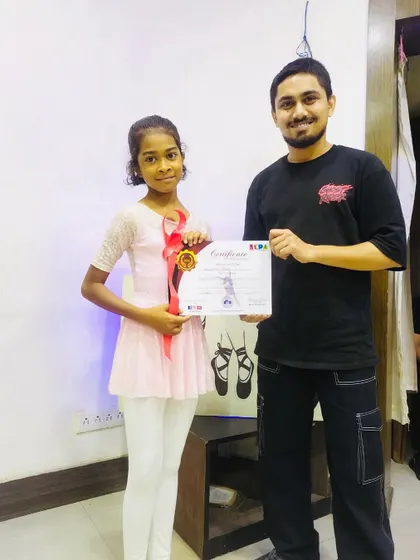 A young ballerina receiving her certificate. I offer specialized courses and certification in specific dance styles like ballet.