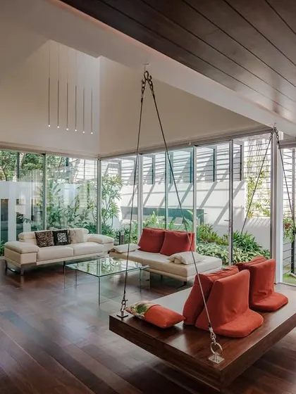 Another view of the family space, highlighting the wooden ceiling that extends towards the garden, visually connecting the indoor and outdoor areas. The layout ensures that the landscape is a constant backdrop to family life.