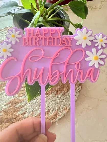 Of lilacs and daisies. This layered acrylic topper in shades of purple and pink is adorned with cute daisy flowers for a fresh and feminine birthday cake.