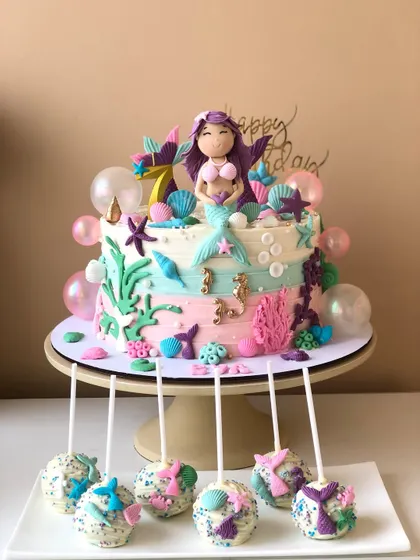 The full mermaid dessert set, showcasing the main cake and the beautifully decorated cake pops together.