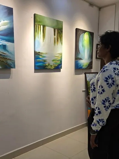 A visitor takes in the dreamlike landscapes of artist Gurpreet Kaur, whose solo exhibition blended oil and acrylic techniques.
