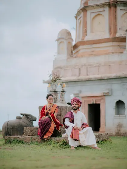 A relaxed portrait of a couple sitting on the steps of a historic temple.