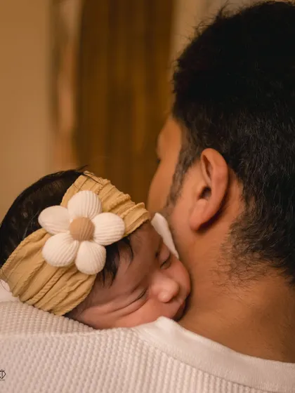 A tender moment between a father and his newborn daughter. Capturing this secure and loving embrace is a key part of documenting the story of a new family.