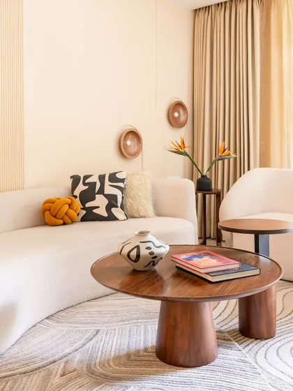 A closer view of the custom coffee table and curved sofa, showcasing the interplay of organic shapes and natural materials that define this home's Wabi-Sabi style.