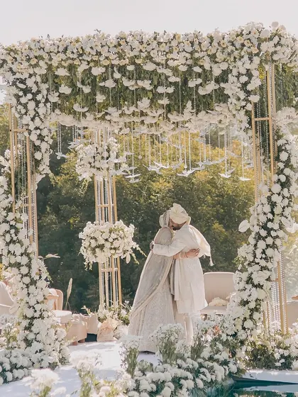 An all-white floral mandap creating a heavenly, dream-like setting for an elegant and modern wedding ceremony.