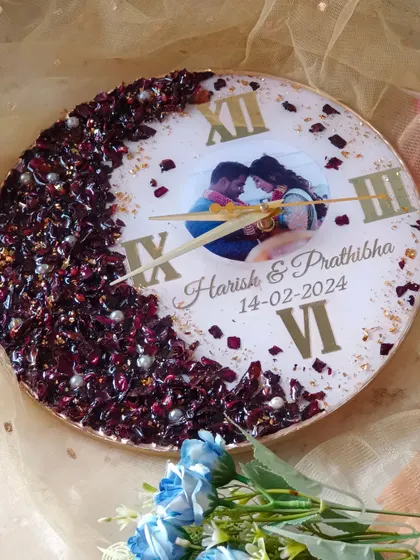A beautiful resin clock with a half-moon of preserved red flowers and the couple's photo. The gold flakes and pearl details add a touch of sparkle and elegance.