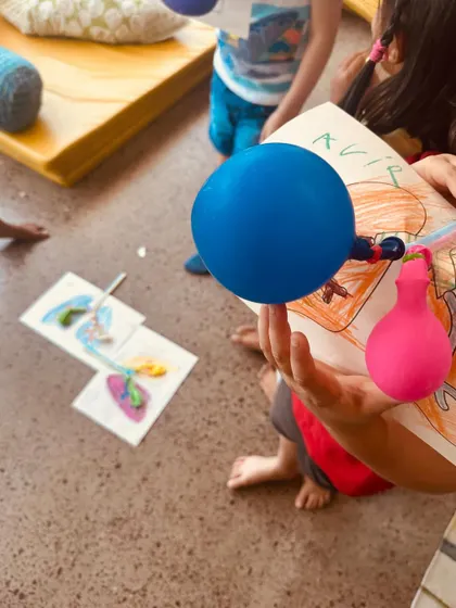 A child holds up the balloon lung model they created. This hands-on activity made an abstract biological concept tangible and easy to understand, creating a lasting memory.