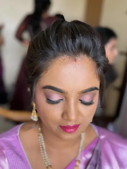 A close-up on the details. This soft glam look for an engagement party features delicate pink eyeshadow, full lashes, and a matching pink lip for a cohesive and pretty finish.