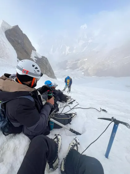 Taking a break on the snow. The Friendship Peak expedition requires proper gear like ice axes and crampons.