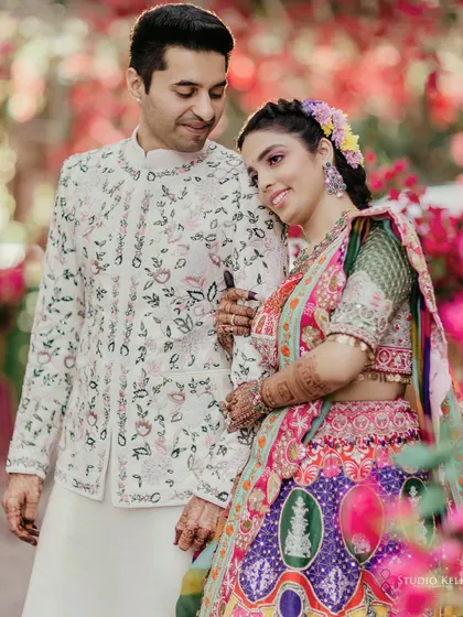 A close and tender portrait of the couple amidst a garden of pink flowers, capturing their soft and romantic side.