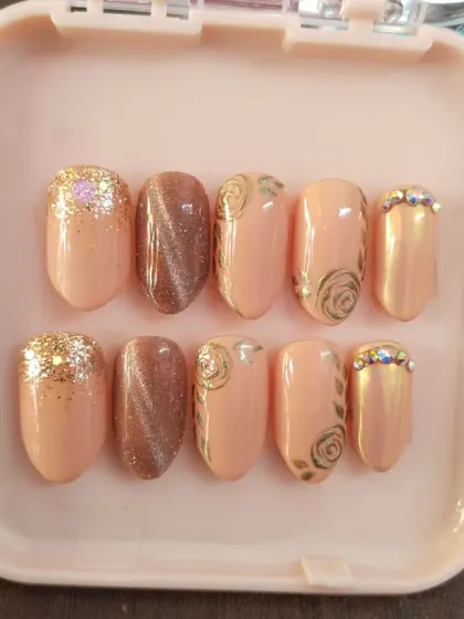 A clear, top-down view of the engagement nail set. You can see the mix of textures and finishes, from the smooth cat eye to the sparkling glitter and detailed rose art.