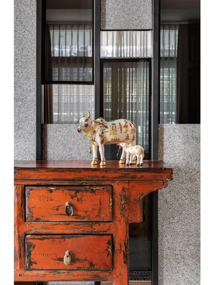 A detail of the foyer in Nataraj House, featuring a distressed-finish console table that adds a touch of eclectic, rustic charm.
