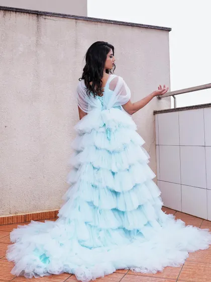A view from the back, highlighting the gown's train and the model's soft hairstyle. The entire look is designed to be picture-perfect from every perspective.