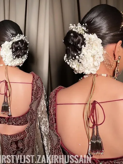 A close-up of the bridal bun, showing the detail of the white hydrangeas and the sleek finish of the hair.