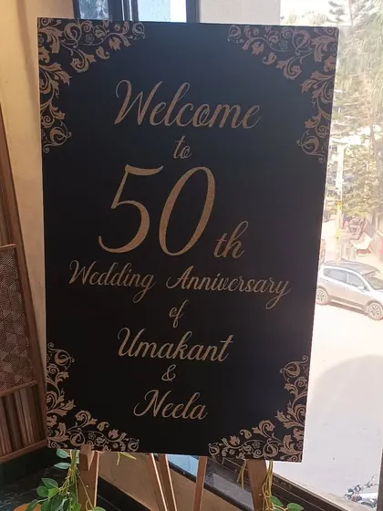 A classic black and gold welcome sign for the 50th wedding anniversary of Umakant and Neela.