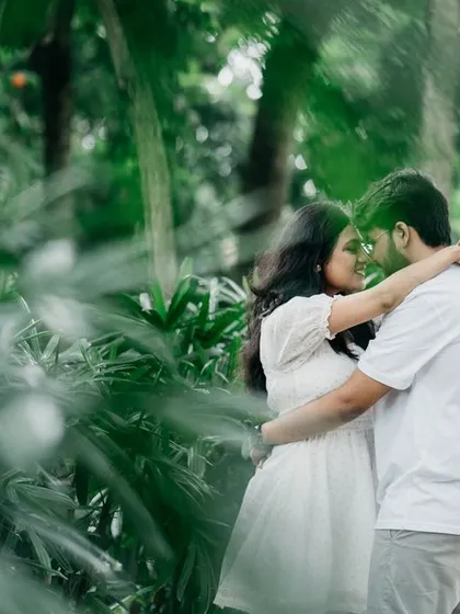Framed by palm leaves, this image captures an intimate embrace. Using natural elements for framing adds depth and a sense of privacy to your pre-wedding photos.
