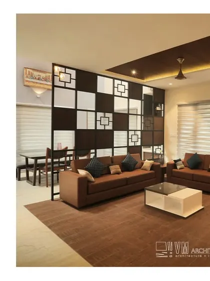 The living room in our Adoor residence is separated from the dining area by a stylish geometric partition, creating distinct zones while maintaining an open feel.