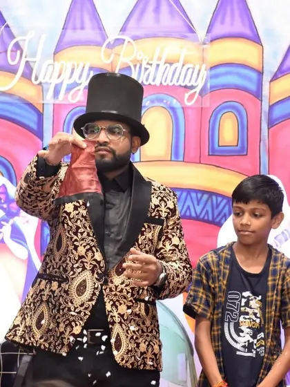 A young volunteer helps me with a classic bag trick. His focus and participation make the show even more entertaining for everyone.