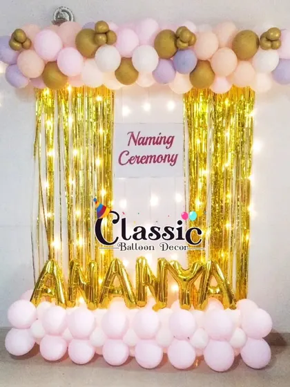 A simple and sparkly naming ceremony backdrop. We used a golden foil curtain, fairy lights, and foil letter balloons to spell out the baby's name.