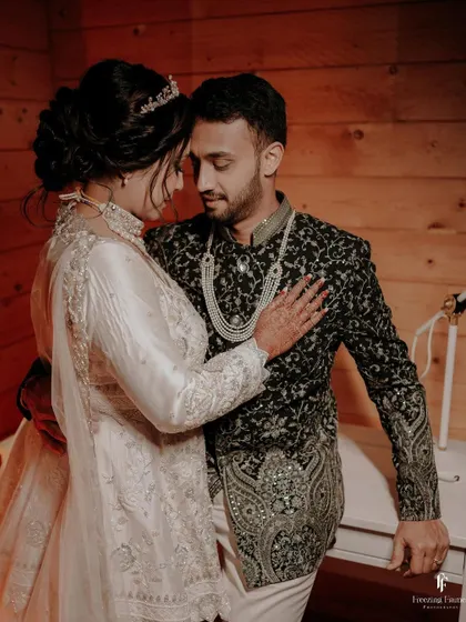An intimate portrait of the couple in a rustic, wood-paneled setting, their embrace full of warmth.