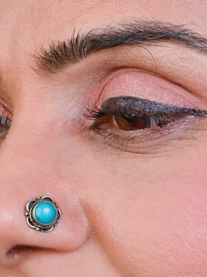 A beautiful oxidized nose pin with a turquoise stone, perfect for a traditional and bohemian look.
