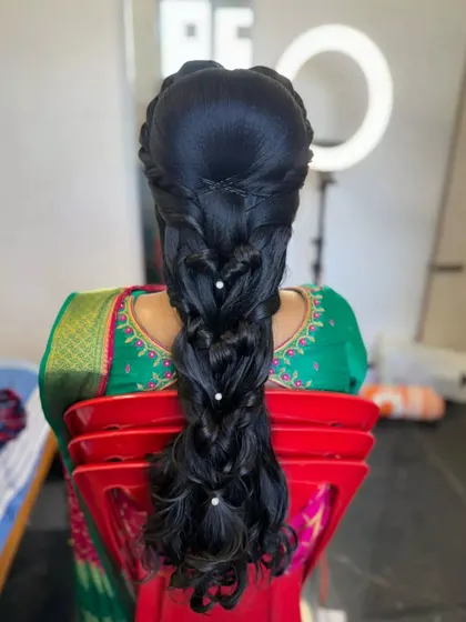 A creative heart-shaped pull-through braid with pearl accents, showcasing a unique and romantic design.