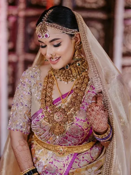 The bride's veil is lifted, revealing her beautiful smile and stunning blouse. The intricate details of the embroidery are on full display.
