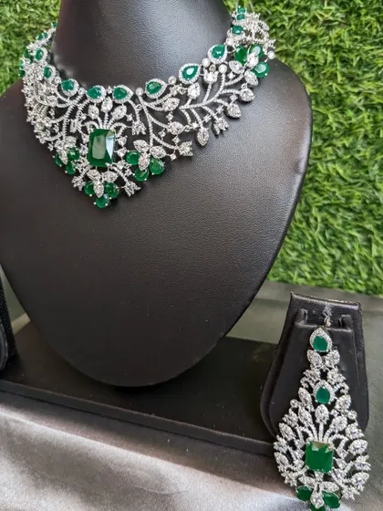 This simple AD necklace with emerald stones and glamorous matching earrings is a versatile set that goes with almost any party outfit.