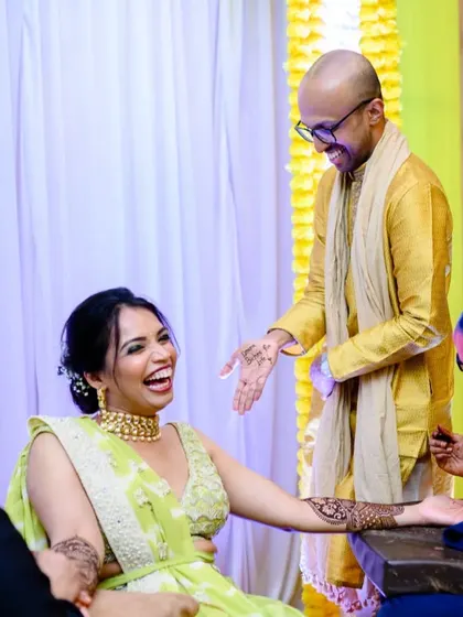 Amrutha's reaction to Ashwin's surprise mehendi. Their shared laughter is a testament to their fun loving relationship.