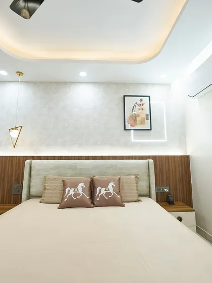 The horse-themed cushions add a touch of personality to this otherwise neutral and serene bedroom. The geometric pendant light is a modern and stylish addition.