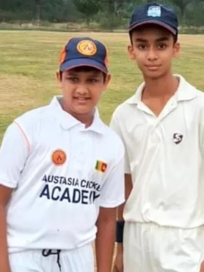 One of our players standing with a player from the Austasia Cricket Academy, Sri Lanka, fostering international sportsmanship.