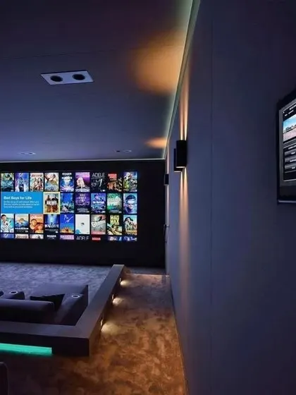 This theater includes a wall-mounted smart control panel, allowing for easy adjustments to lighting, sound, and screen settings from one central location.