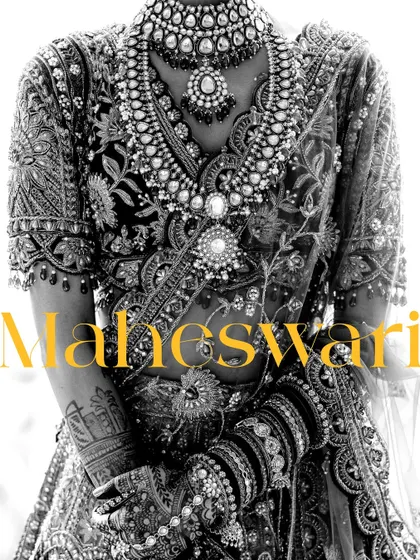 A powerful black and white close-up of the bride's torso, highlighting the incredibly detailed embroidery and jewelry of her bridal look.