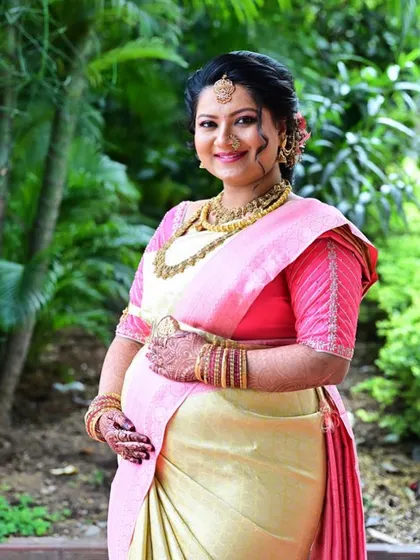 Dr. Nikitha looking absolutely radiant for her baby shower. This outdoor shot captures the soft, natural finish of her makeup, designed to celebrate her pregnancy glow.