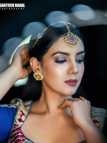 A creative portrait using a circular light flare to frame the model's face, adding an artistic touch to this ethnic fashion shot.