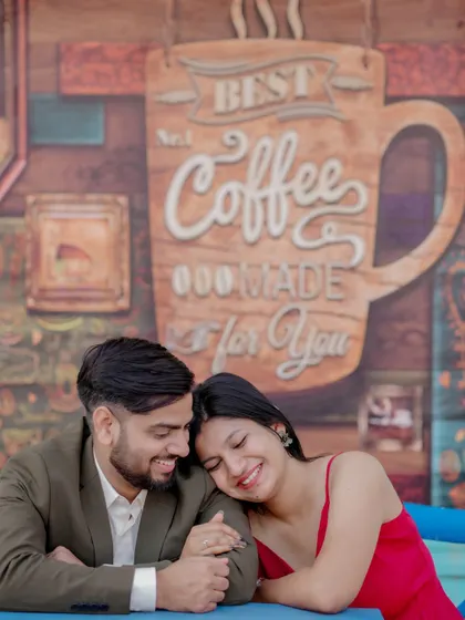 A cozy and romantic moment at a cafe-themed set. The couple's intimate pose and the charming background create a sweet, story-driven image perfect for their pre-wedding album.