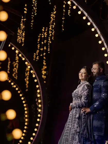 I love using creative lighting to make couple portraits that stand out. For this shot at the Shrusti Farmhouse in Panvel, we used the venue's decorative lights to create a beautiful, romantic frame around the couple, making for a memorable reception photo.